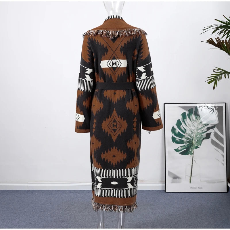 Mannequin wearing a patterned dress with a white wall and framed picture in the background