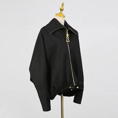 Black jacket with gold zipper on a mannequin against a gray background