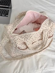 Quilted floral print duffle top, partially open with contents visible