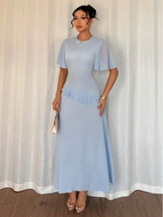 Woman wearing a light blue dress with a plain background