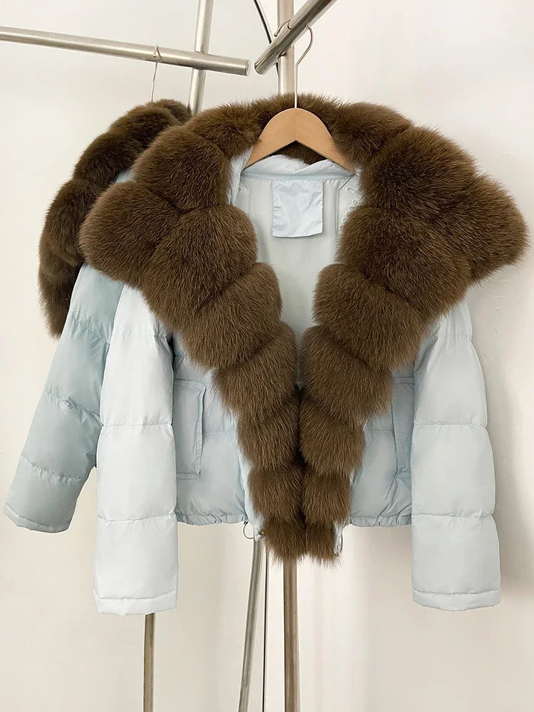 Light blue puffer jacket with brown fur collar on a hanger against a white background