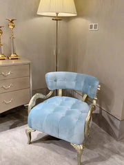 Light blue armchair with gold accents in a room setting