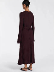 Woman wearing a long burgundy dress on a white background
