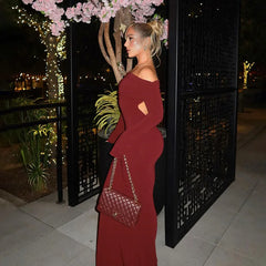 A model wearing an elegant off-the-shoulder maxi dress, showcasing its versatility with both long sleeves and a strapless option.