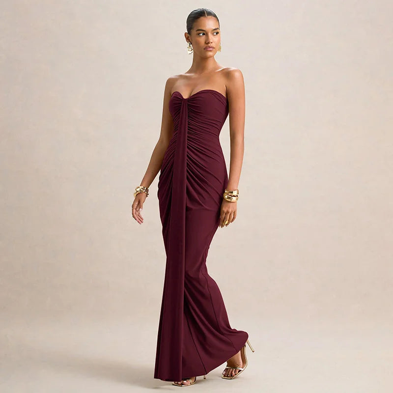 Woman wearing a burgundy strapless gown on a beige background