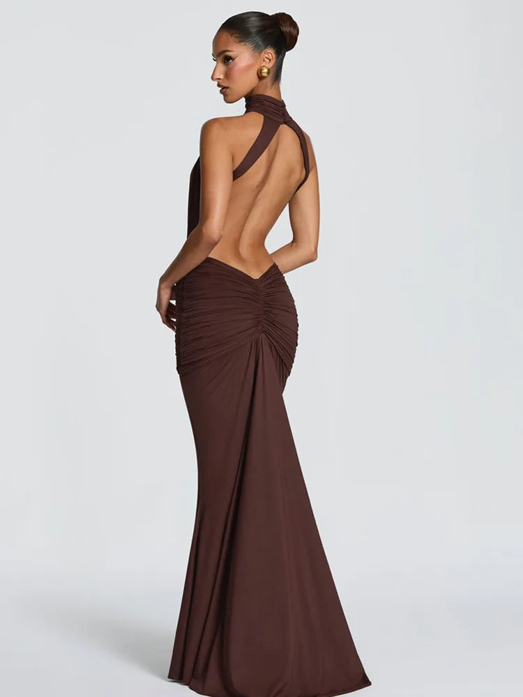 Woman wearing a brown evening gown with a high slit on a white background