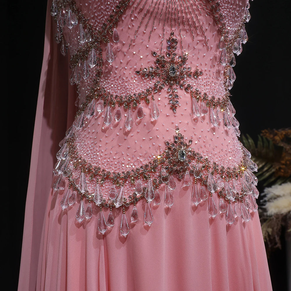 Pink dress with intricate beading and crystal details on a dark background