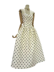 White dress with black polka dots on a mannequin against a white background