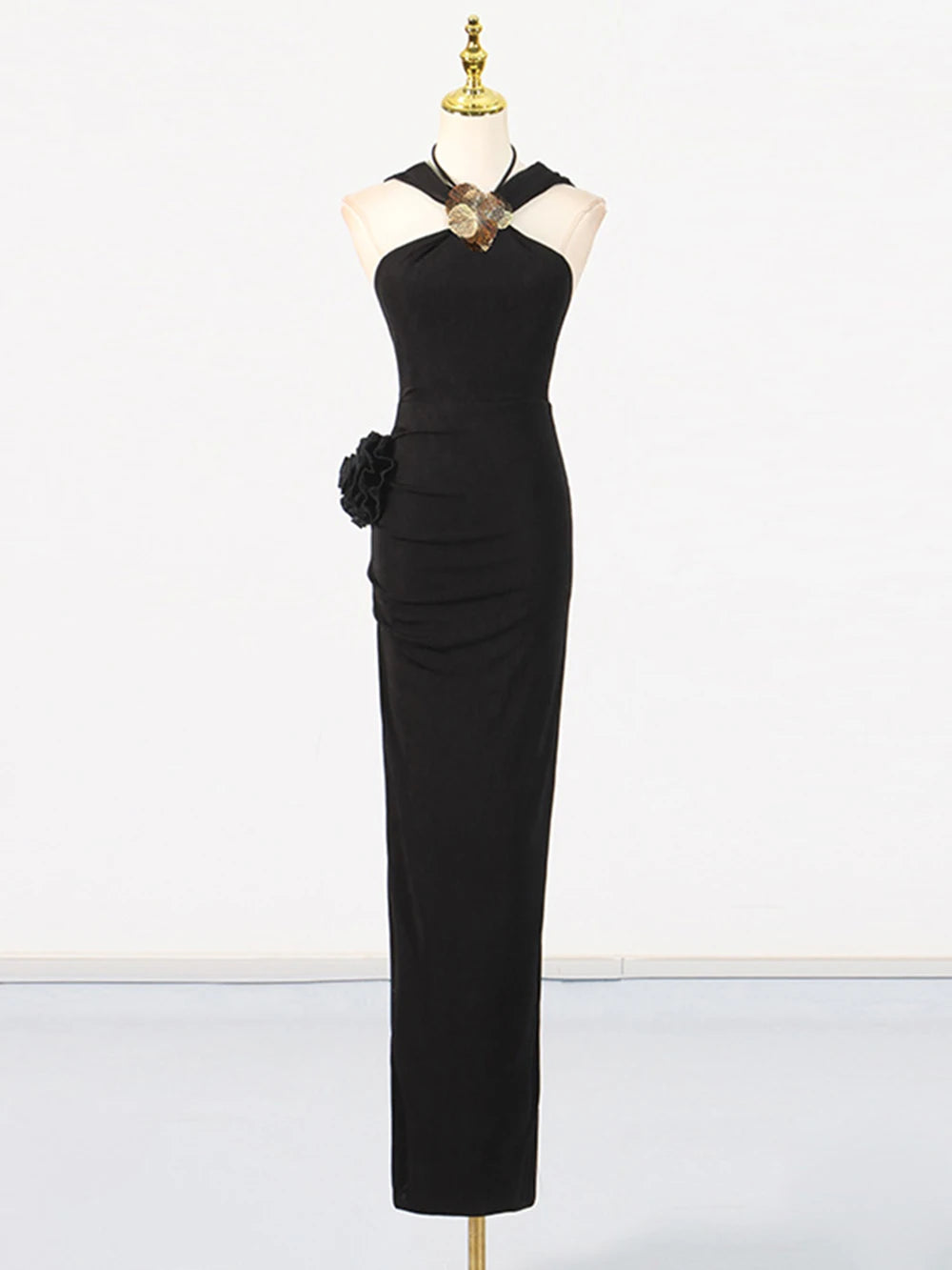Black evening gown on a mannequin against a white background