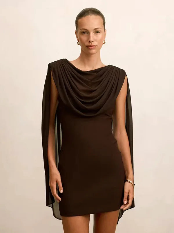 Woman wearing a brown dress with draped shoulders against a beige background