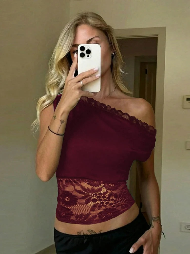 Woman taking a mirror selfie wearing a burgundy lace top.