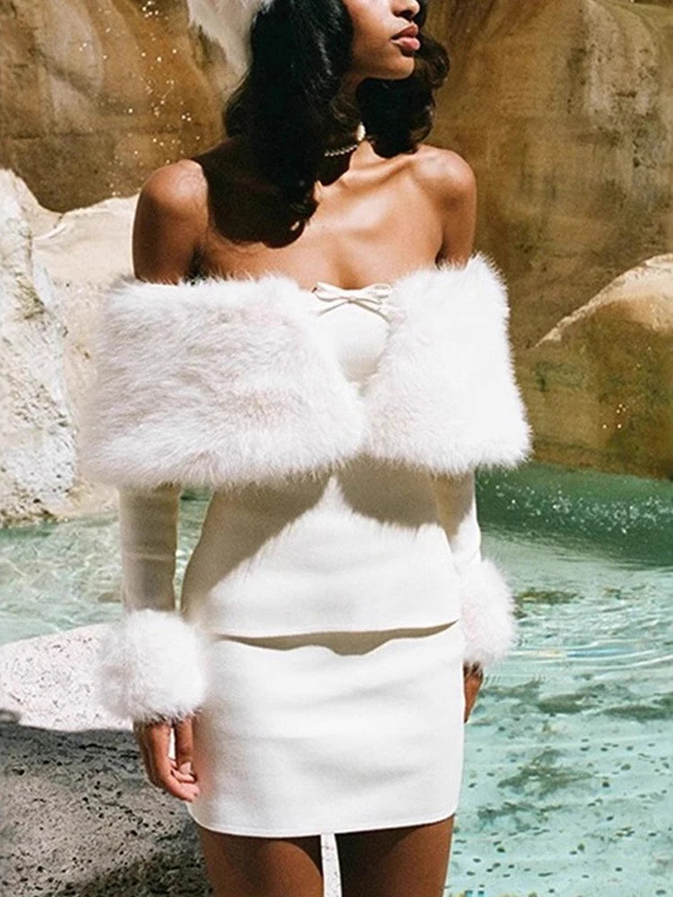 Woman wearing a white dress with fur accents by a poolside.