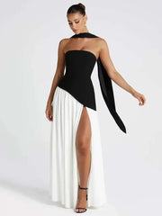 Woman wearing a black and white dress with a long black ribbon on a white background