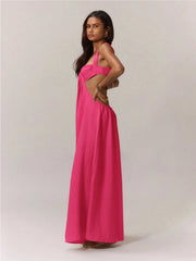 Woman wearing a pink jumpsuit with a cut-out design on a plain background