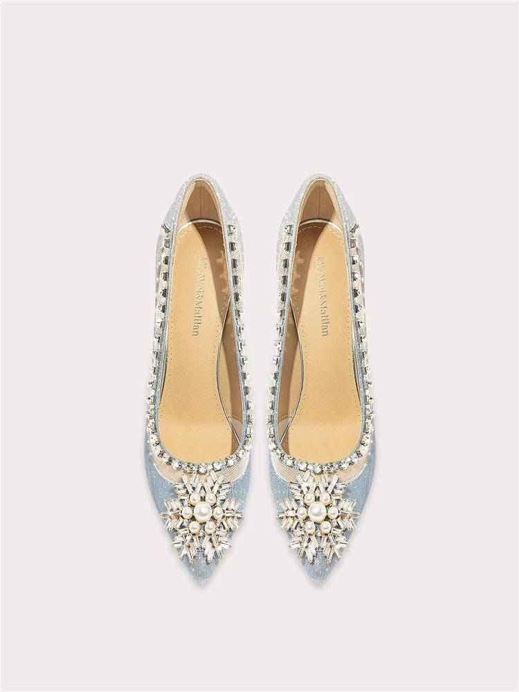 Pair of light blue high-heeled shoes with decorative embellishments on a white background