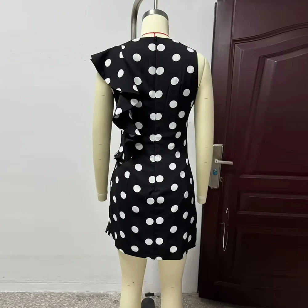 Black dress with white polka dots on a mannequin against a door background