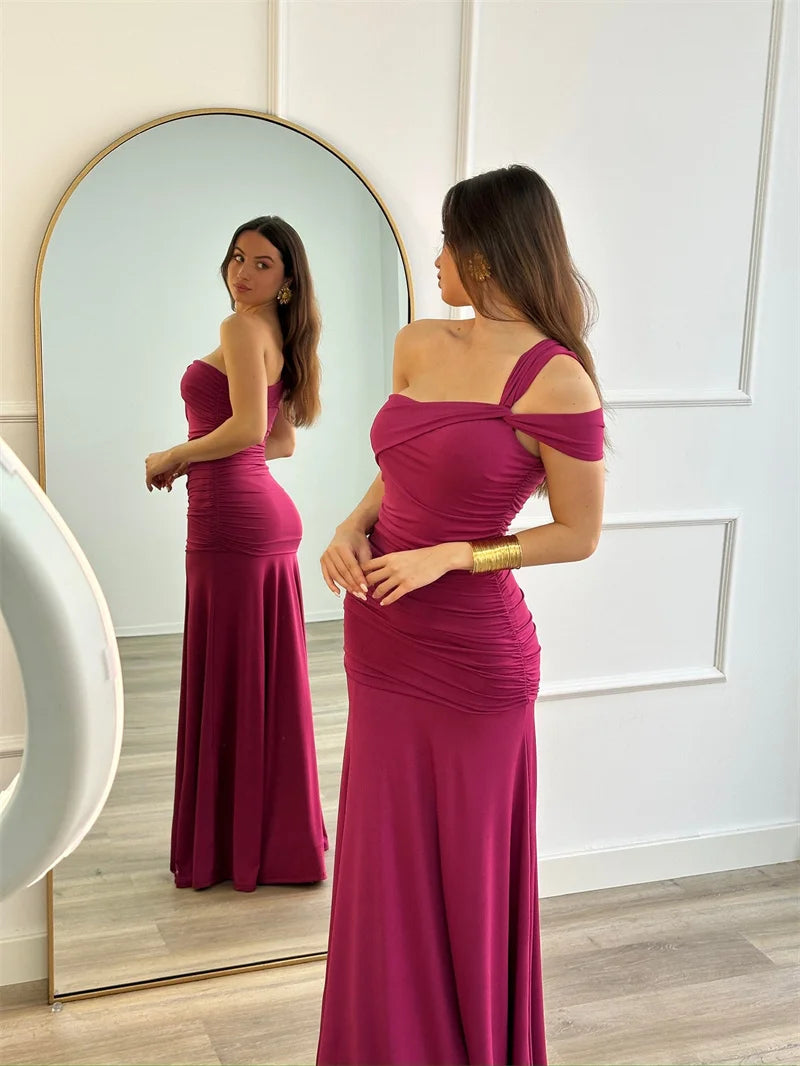 Woman in a pink evening gown standing in front of a mirror.