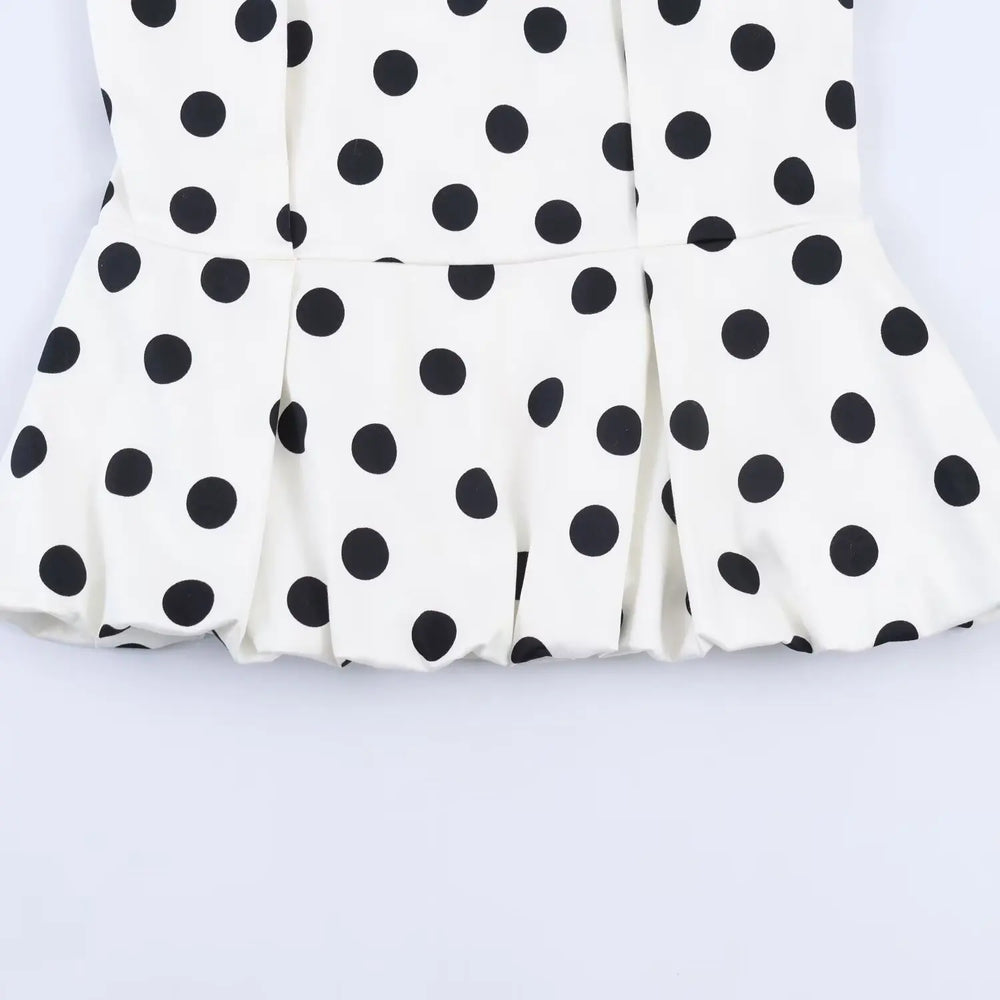 White fabric with black polka dots on a light gray background