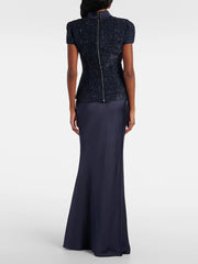 Woman wearing a navy two-piece set featuring a short-sleeve buttoned top and floor-length sheath skirt — elegant summer office or event outfit