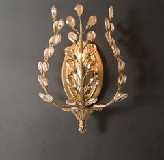 Gold wall sconce with leaf design on a dark background