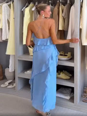 Woman in a blue dress standing in front of a wardrobe with clothes and shoes.