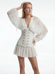 Woman wearing a white dress with a corset-style bodice on a white background