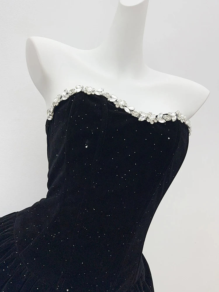 Black strapless dress with decorative neckline on a mannequin against a white background