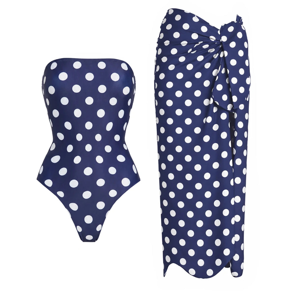 Navy and white polka dot strapless one-piece swimsuit with a matching wrap-style sarong