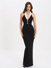 Black evening gown with white accents worn by a model on a white background