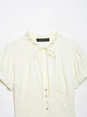 Light yellow blouse with buttons on a white background