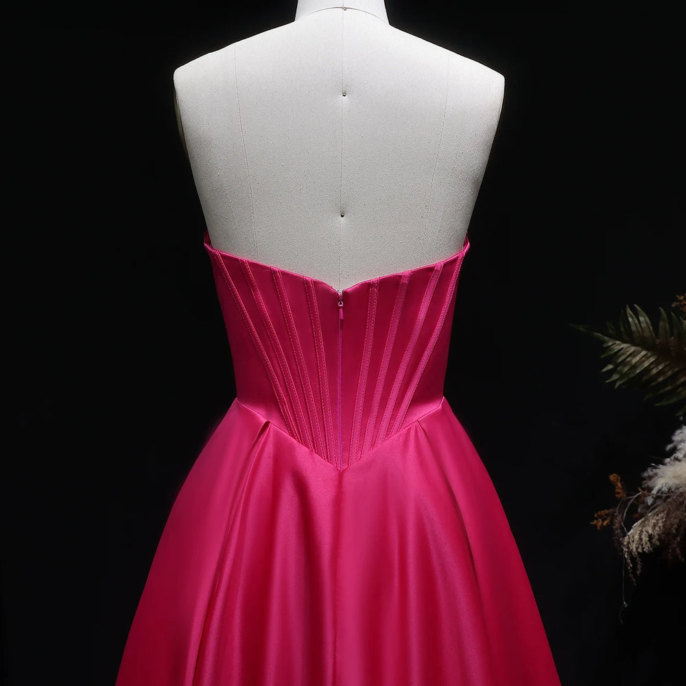Pink evening gown on a mannequin against a dark background