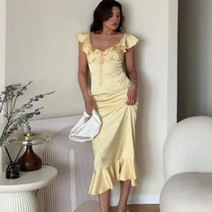 Floral ruffle off-shoulder midi dress standing with handbag