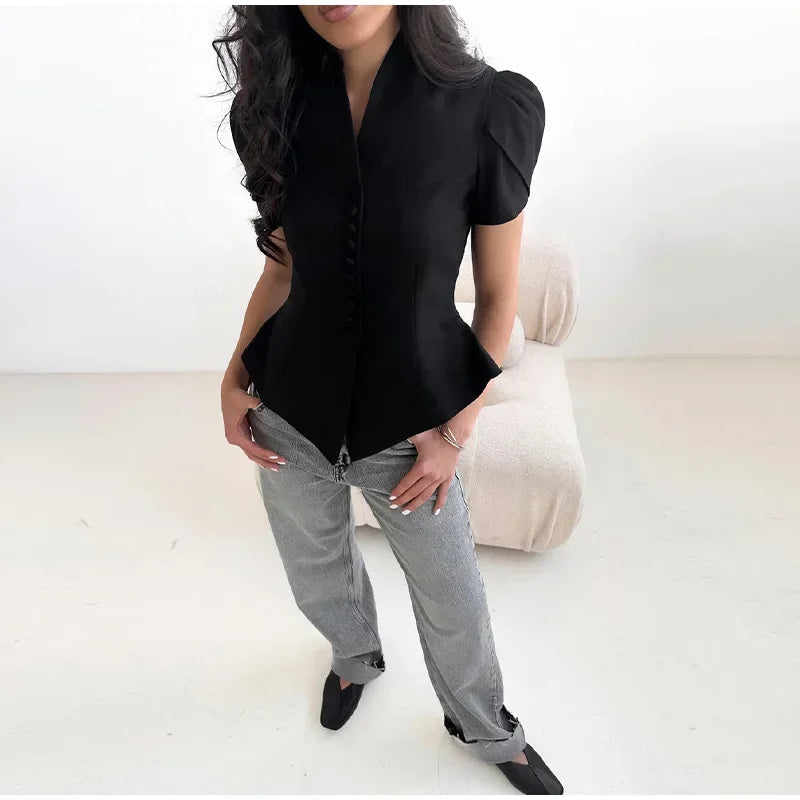 Person wearing a black blouse and gray pants on a white background