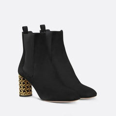 Pair of black suede ankle boots with gold hollow heels