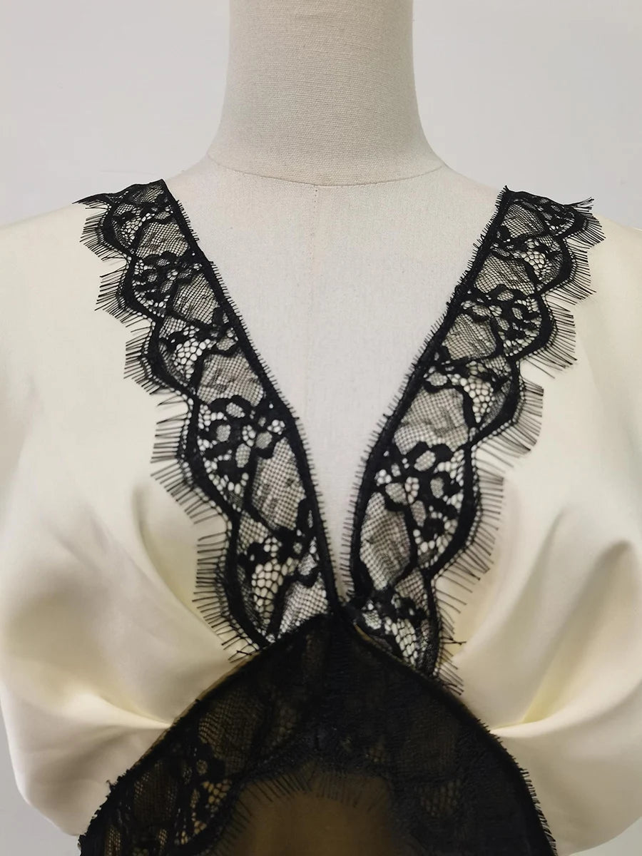 Mannequin wearing a white garment with black lace detailing
