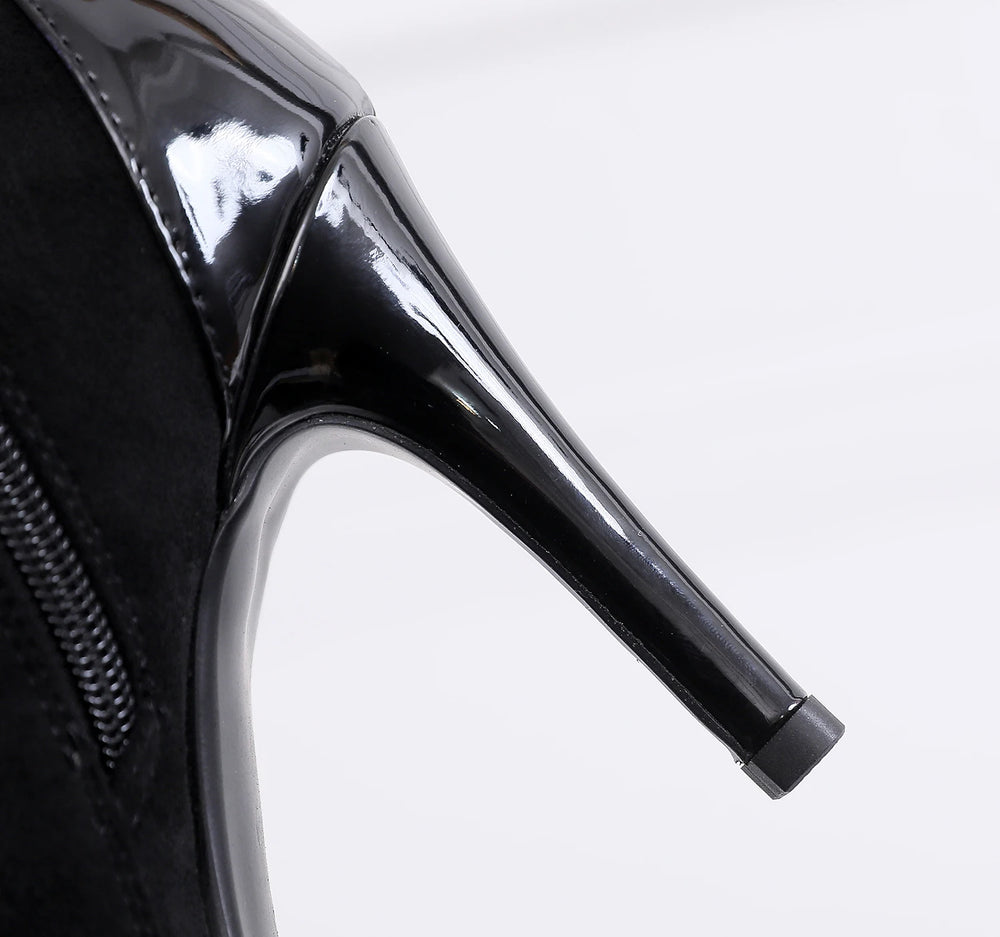 Close-up of a black high-heeled shoe on a white background