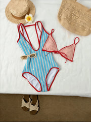 Blue and white striped one-piece swimsuit with red trim, pink lace bikini top, straw hats, woven bag, sunglasses, and sandals