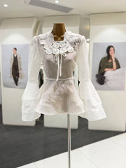 White lace dress on a mannequin in an indoor setting with blurred background