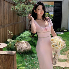 Woman in a pink dress holding flowers in an outdoor setting