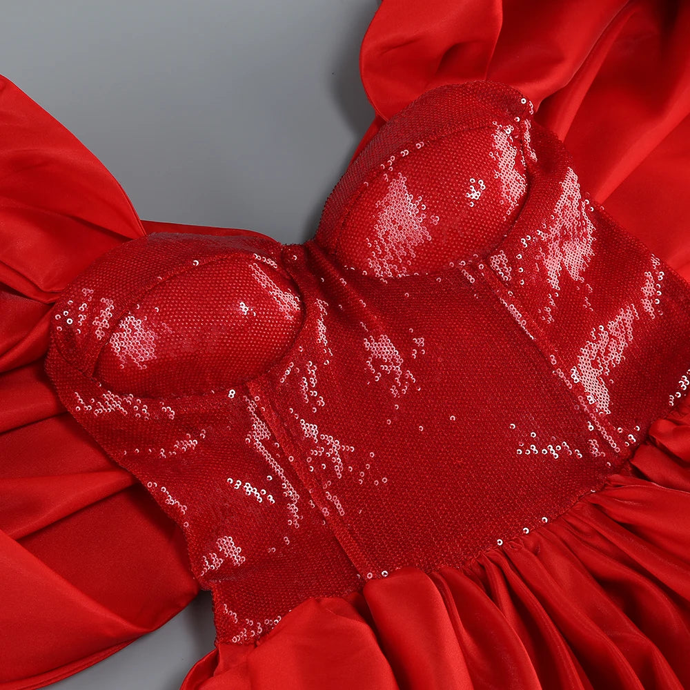 Close-up of a red dress with sequin details on a gray background