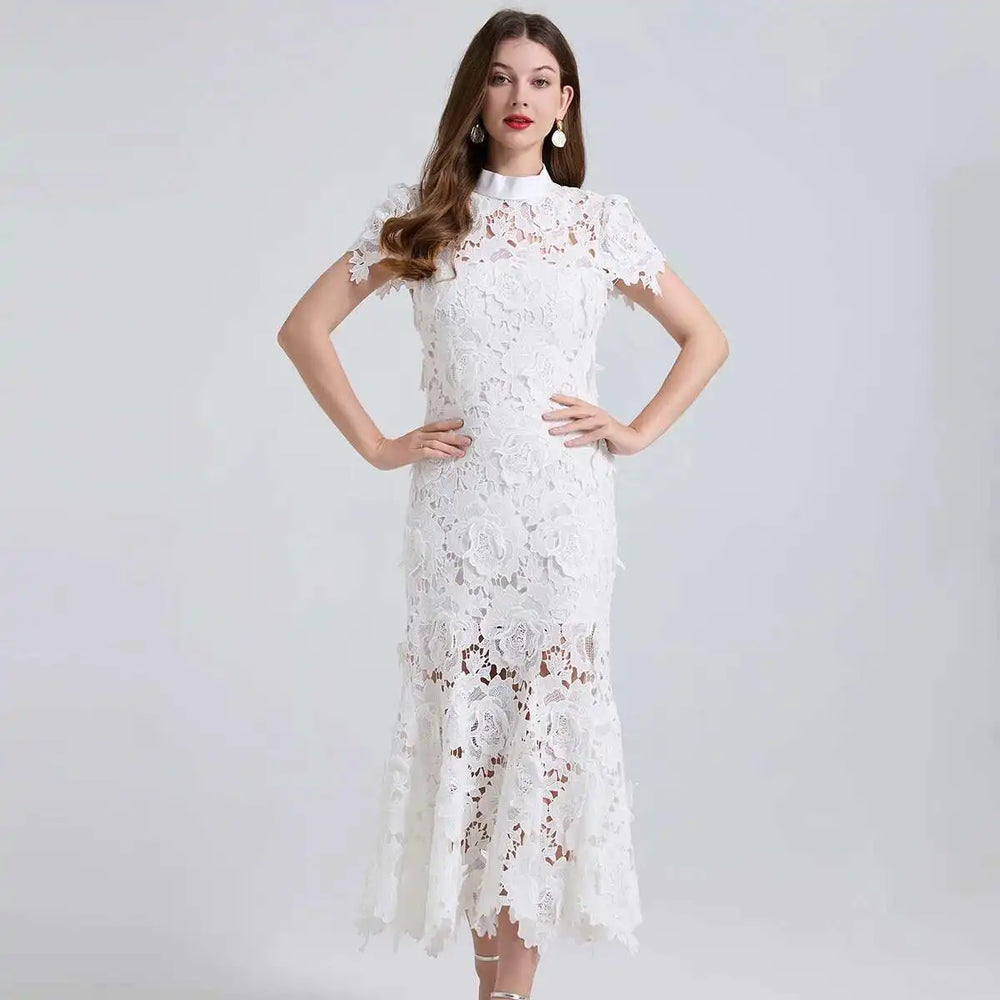 Woman wearing a white lace dress against a plain background