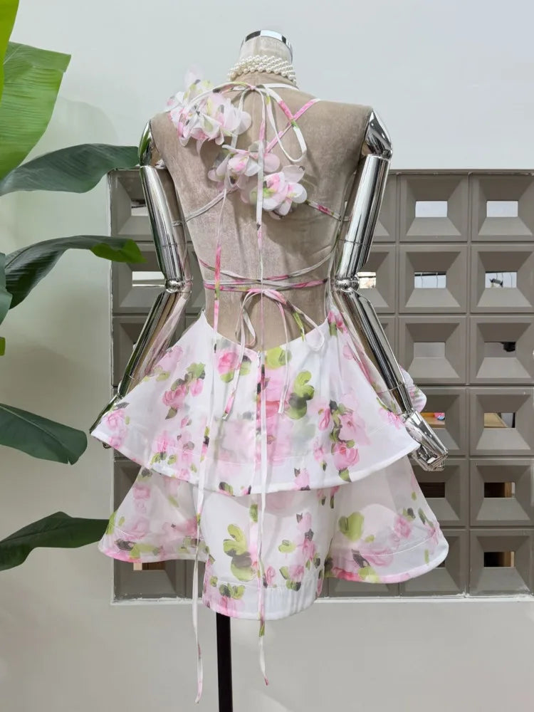 Floral print halter neck mini dress with blossom embellishments on bodice and back ties.
