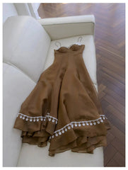Brown lace-trimmed A-line midi dress folded on couch