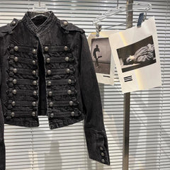 Close-up of the double-breasted buttons on a black denim jacket.