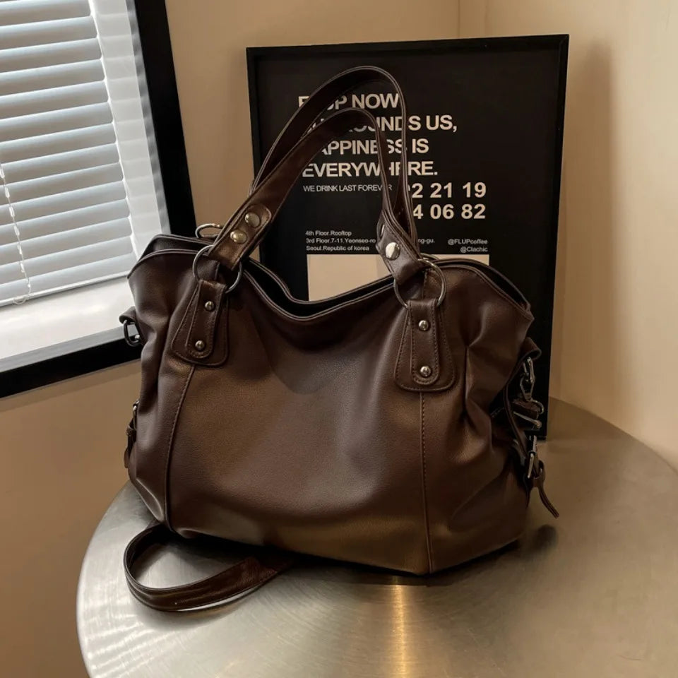 Brown tote bag with rivet details placed on a table