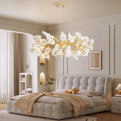 Modern bedroom with a floral chandelier, bed, and decor.