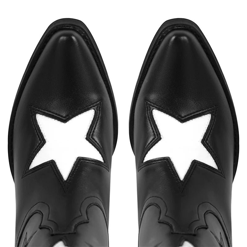 Close-up of the pointed toe of black cowboy boots with white star detail.