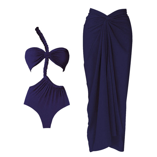 Close-up view of a navy one-piece swimsuit with a one-shoulder strap and a draped maxi skirt, shown as a set.