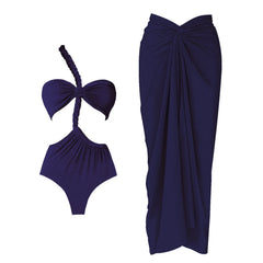 Close-up view of a navy one-piece swimsuit with a one-shoulder strap and a draped maxi skirt, shown as a set.