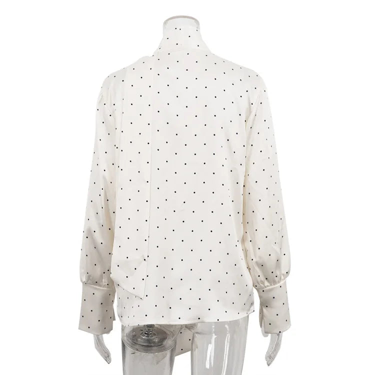 White blouse with black polka dots on a mannequin against a white background